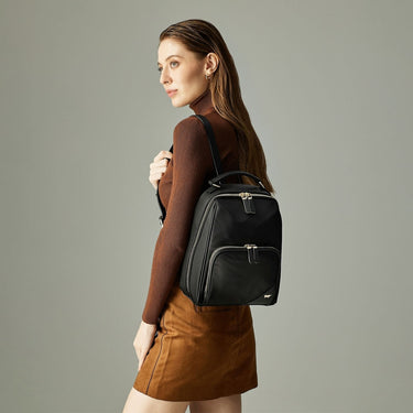 Fashion lookbook shot of a black Braun Büffel backpack paired with a sleek urban outfit