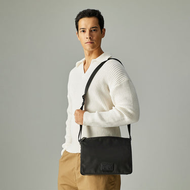 Man styling a Braun Büffel black shoulder bag